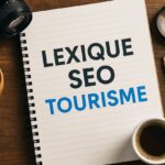 Carnet avec le titre "Lexique SEO Tourisme" posé sur un bureau en bois, entouré d’un appareil photo, d’une loupe et d’un café — image illustrant un guide de référencement naturel pour les professionnels du tourisme.